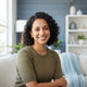 A professional portrait of a smiling woman in a bright, modern home setting, representing a satisfied customer.